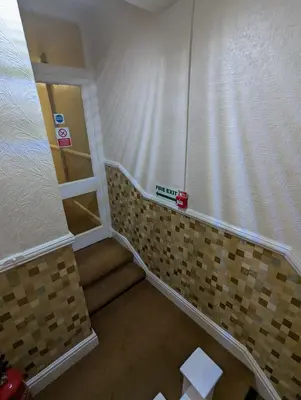 a small bathroom with a staircase and a wall of tiles at The Stafford in Blackpool