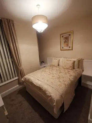 a bedroom with a large bed and a chandelier at The Stafford in Blackpool