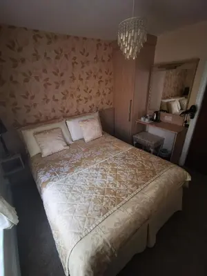 a bedroom with a large bed with a chandelier at The Stafford in Blackpool