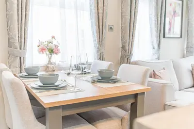 a dining room table with two chairs and a tableablish at Tastefully decorated lodge on popular holiday park, easy access to Lakes and Dales and free parking in Carnforth