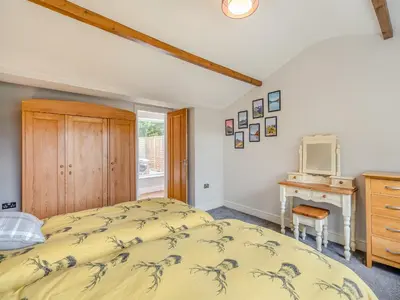 a bedroom with a bed and a desk and a mirror at The Cottage At Breeze Hill in Storth