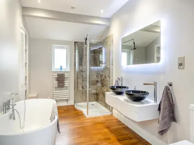 a white bathroom with two sinks and a shower at The Cottage At Breeze Hill in Storth