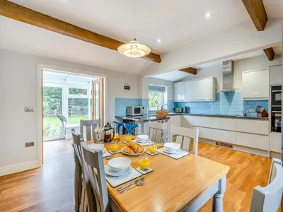 a kitchen and dining room with a wooden table and chairs at The Cottage At Breeze Hill in Storth