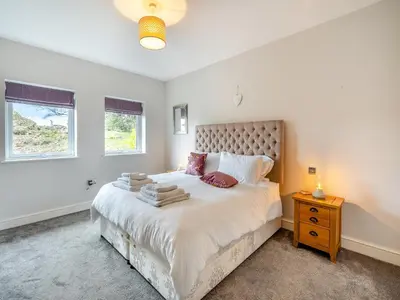 a bedroom with a large bed and a window at The Cottage At Breeze Hill in Storth