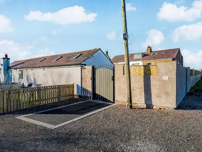 a building with a gate and a fence at The Hideaway in Great Meols