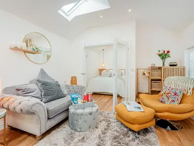 a living room with a couch and a bed at The Hideaway in Great Meols
