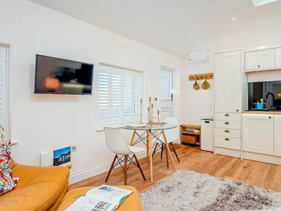 a living room with a couch and a table at The Hideaway in Great Meols