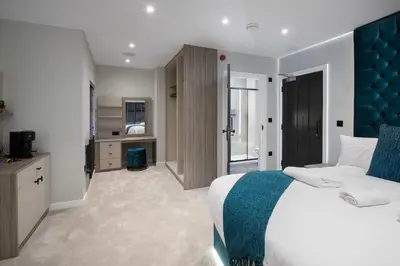 a bedroom with a large bed with a blue headboard at The Charleston in Blackpool
