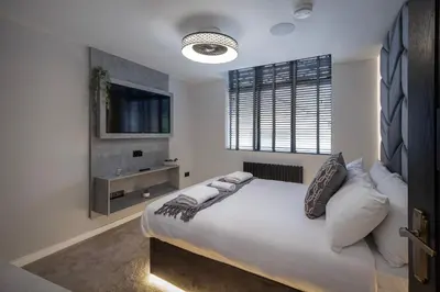 a bedroom with a large bed with white sheets and pillows at The Charleston in Blackpool