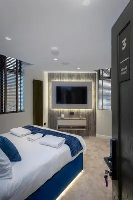 a bedroom with a large bed with a flat screen tv at The Charleston in Blackpool