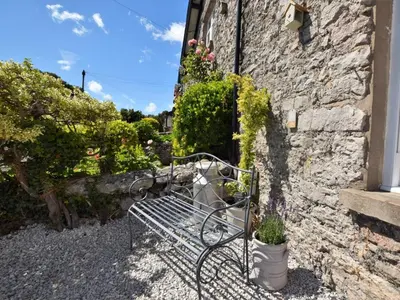 a bench sitting next to a stone building at 2 Bed in Grange-over-sands oc-73544 in Grange Over Sands