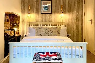 a bedroom with a white bed with a british flag pillow at City Centre Georgian Qtr Apartment Canning St 2bed 2bath in Liverpool