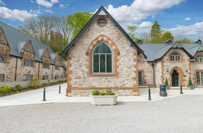 a brick church with a large window and a pot of flowers at Chequers Lodge- Dalton-in- Furness- Self check in- for professionals and tourists in Dalton in Furness