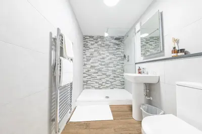 a white bathroom with a toilet and a sink at Chequers Lodge- Dalton-in- Furness- Self check in- for professionals and tourists in Dalton in Furness