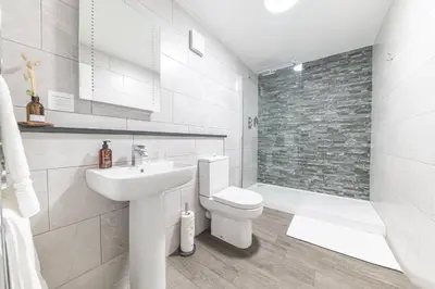 a white bathroom with a toilet and a sink at Chequers Lodge- Dalton-in- Furness- Self check in- for professionals and tourists in Dalton in Furness