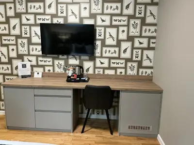 a desk with a television on a wall with a wall covered in crosses at Chequers Lodge- Dalton-in- Furness- Self check in- for professionals and tourists in Dalton in Furness