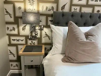 a bedroom with a bed and a nightstand with a lamp at Chequers Lodge- Dalton-in- Furness- Self check in- for professionals and tourists in Dalton in Furness