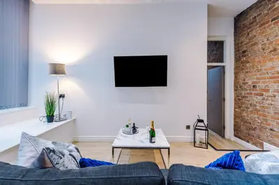 a living room with a couch and a brick wall at Modern 2-Bedroom Apt In the Heart of City Centre in Liverpool