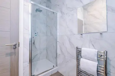 a shower with a glass door in a bathroom at Modern 2-Bedroom Apt In the Heart of City Centre in Liverpool