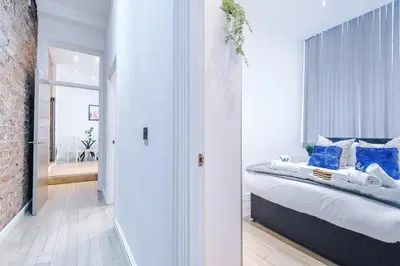 a bedroom with a large bed with blue pillows at Modern 2-Bedroom Apt In the Heart of City Centre in Liverpool