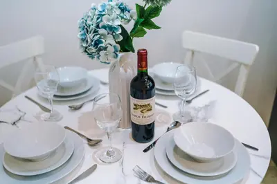 a white table with a bottle of wine and glasses at Modern 2-Bedroom Apt In the Heart of City Centre in Liverpool