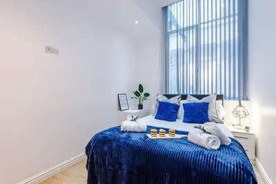 a bedroom with a blue bed with towels on it at Modern 2-Bedroom Apt In the Heart of City Centre in Liverpool