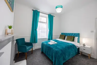 a bedroom with a blue bed and a blue chair at Cosy Four Bedroom Terrace Rishton in Rishton