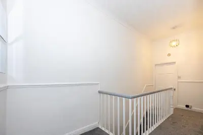 a white room with a staircase and a white wall at Cosy Four Bedroom Terrace Rishton in Rishton
