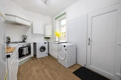 a white kitchen with a washer and dryer at Cosy Four Bedroom Terrace Rishton in Rishton