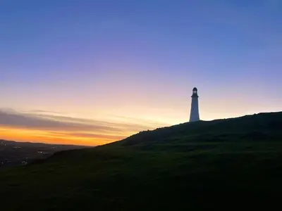 a lighthouse on top of a hill at sunset at Hardy Hideaway in Ulverston