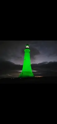 a green lighthouse is lit up at night at Hardy Hideaway in Ulverston