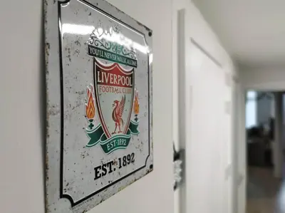 a sign hanging on a wall in a room at Unique LFC Themed House in Liverpool