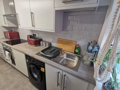 a kitchen with a sink and a washing machine at Unique LFC Themed House in Liverpool