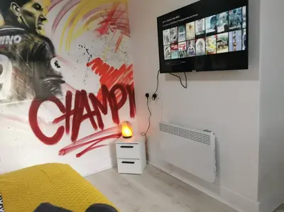 a room with a tv and a bed and a lamp at Unique LFC Themed House in Liverpool
