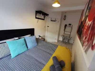 a bedroom with a bed with blue and white pillows at Unique LFC Themed House in Liverpool