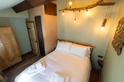 a bedroom with a bed with white sheets and pillows at The Bolt Hole in Morecambe