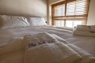 a bed with white towels on it with a window at The Bolt Hole in Morecambe