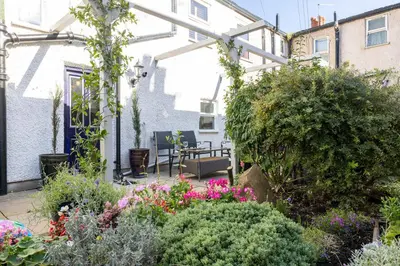 a garden with plants and flowers in front of a house at The Bolt Hole in Morecambe