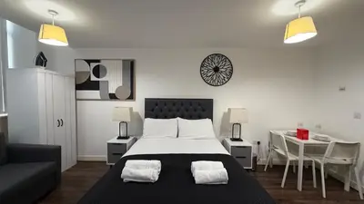 a bedroom with a large bed with two chairs and a table at The Strand, Studio - Pass the Keys in Liverpool