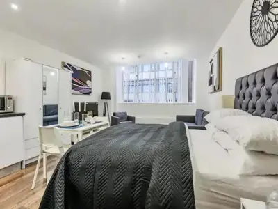 a bedroom with a large bed and a desk in it at The Strand, Studio - Pass the Keys in Liverpool