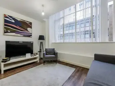 a living room with a flat screen tv and a chair at The Strand, Studio - Pass the Keys in Liverpool