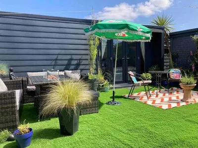 a patio with a table and an umbrella at Beautiful new Garden Annexe in Ashton in Makerfield