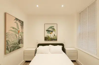 a white bedroom with a bed and a window at Lord Street Lofts in Southport
