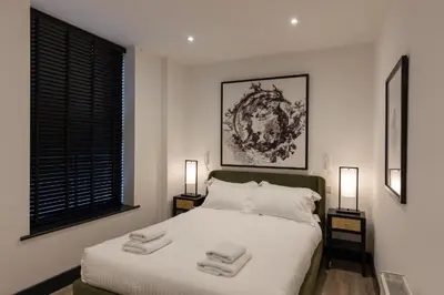 a bedroom with a white bed with two lamps at Lord Street Lofts in Southport