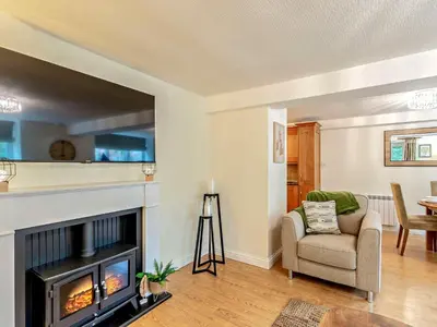 a living room with a fireplace and a chair at 1 Bed in Cartmel LCC15 in Cartmel