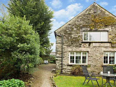 a stone house with a table and chairs in front of it at 1 Bed in Cartmel LCC15 in Cartmel
