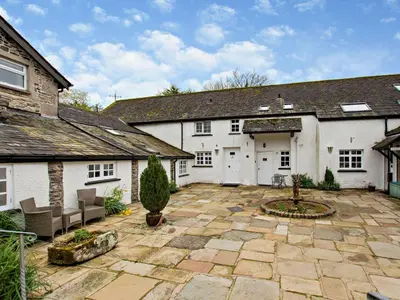 a large white house with a patio in front of it at 1 Bed in Cartmel LCC15 in Cartmel