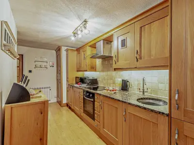 a large kitchen with wooden cabinets and a sink at 1 Bed in Cartmel LCC15 in Cartmel