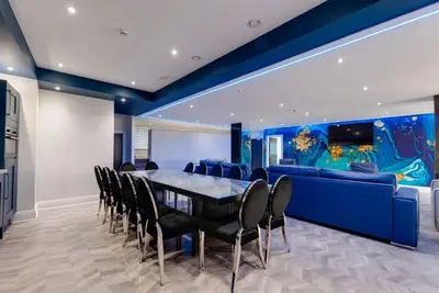 a dining room with a table and chairs and an aquarium at Temple Court Cavern Quarter Apartments by Happy Days in Liverpool