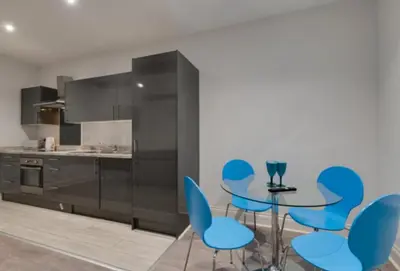 a kitchen with blue chairs and a table at Temple Court Cavern Quarter Apartments by Happy Days in Liverpool
